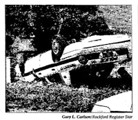 a black and white picture of a car that is upside down