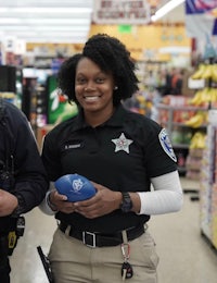 two police officers standing next to each other in a grocery store