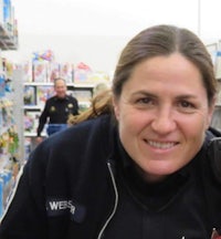 a woman in a police uniform smiles in a toy store