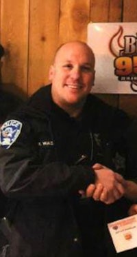 two police officers shaking hands in front of a wooden wall