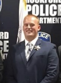 three men in suits standing in front of flags